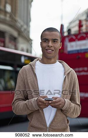 A young man text messaging View Large Photo Image Stock Image - A young man text messaging. Fotosearch