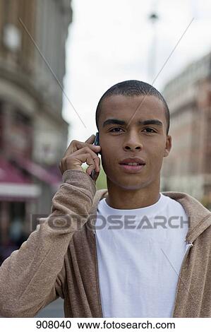 A young man using a mobile phone, portrait View Large Photo Image Stock Image - A young man using a mobile phone, portrait. Fotosearch