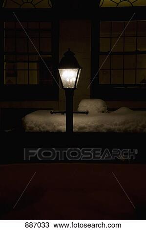 Stock Image - An illuminated street lamp at night in winter. Fotosearch