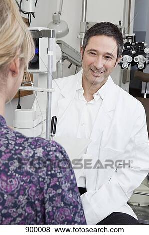 Stock Photo - An ophthalmologist doing a slit-lamp biomicroscope exam on a patient. Fotosearch