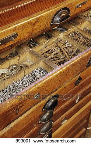 Stock Image - Antique woodworkers tool cabinet drawer filled with various carpentry materials. Fotosearch