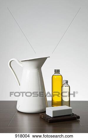 Picture - Aromatherapy oil, a bar of soap and a pitcher. Fotosearch