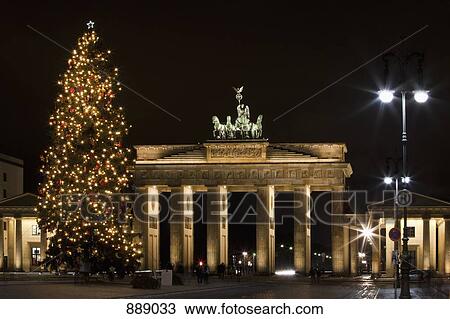 Stock Image - Brandenburg Gate behind a Christmas tree at night, Berlin, Germany. Fotosearch