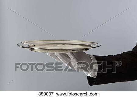 Detail of a butler holding a silver platter View Large Photo Image Stock Photo - Detail of a butler holding a silver platter. Fotosearch