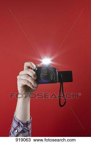 Stock Image - Detail of a man taking a photograph with a camera. Fotosearch