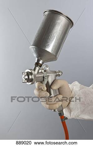 Stock Image - Detail of a person holding a paint spray gun. Fotosearch