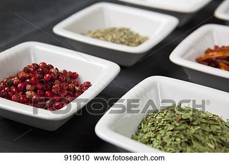Stock Image - Detail of herbs and spices in small bowls. Fotosearch