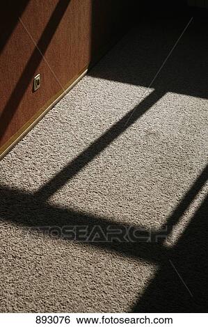 Stock Photograph - Detail of sunlight and shadows on a carpet floor. Fotosearch