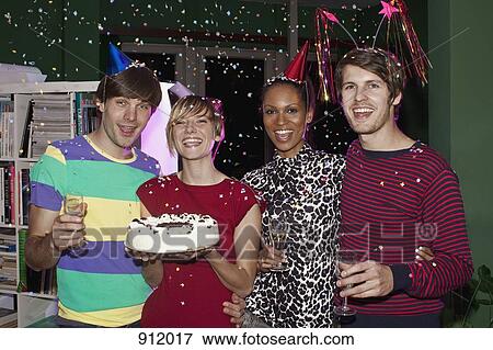 Stock Photo - Four friends celebrating with confetti, champagne and cake. Fotosearch