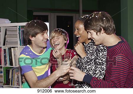 Four friends celebrating with confetti and champagne View Large Photo Image Stock Photograph - Four friends celebrating with confetti and champagne. Fotosearch