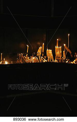 Lit candles arranged on an altar View Large Photo Image Stock Photograph - Lit candles arranged on an altar. Fotosearch