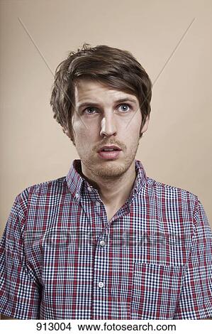 Picture - Portrait of a man looking confused, studio shot. Fotosearch