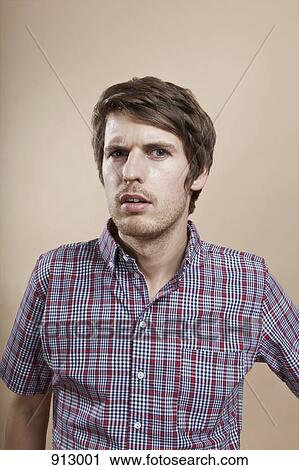 Portrait of a man looking confused, studio shot View Large Photo Image Stock Image - Portrait of a man looking confused, studio shot. Fotosearch