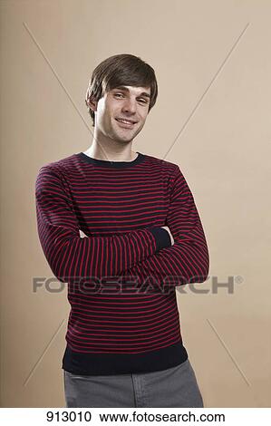 Stock Image - Portrait of a man looking suspicious, studio shot. Fotosearch