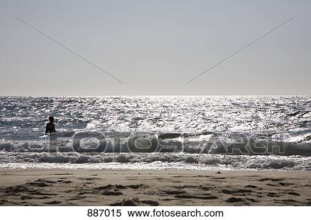 Stock Photography - Silhouette of a man standing in the sea. Fotosearch