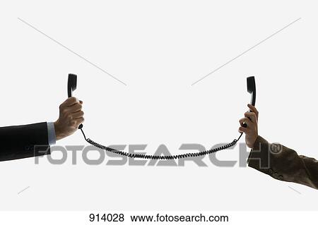 Two business people holding telephone receivers connect with the same cord View Large Photo Image Stock Photo - Two business people holding telephone receivers connect with the same cord. Fotosearch