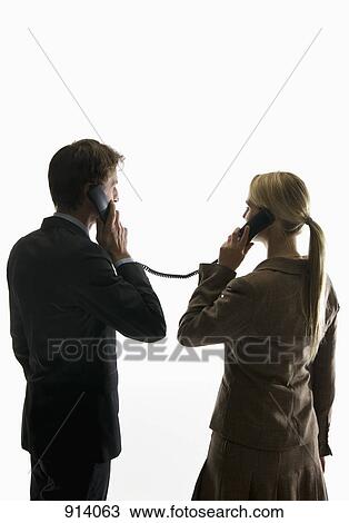 Two business people using phone receivers connected with the same cord View Large Photo Image Stock Image - Two business people using phone receivers connected with the same cord. Fotosearch