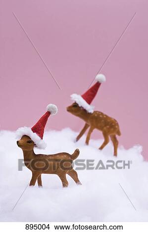 Two reindeer figurines standing in fake snow made out of cotton filling View Large Photo Image Picture - Two reindeer figurines standing in fake snow made out of cotton filling. Fotosearch