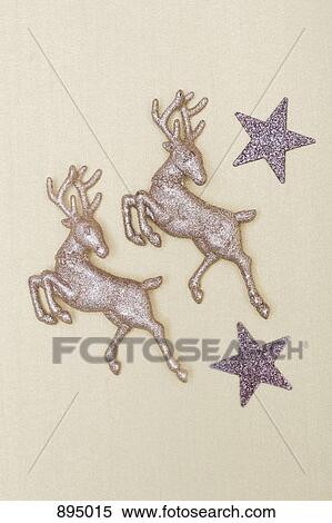 Stock Photography - Two sparkly jumping reindeer figurines and two sparkly stars. Fotosearch