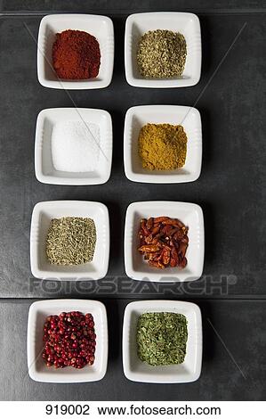Stock Image - Various herbs and spices in small bowls. Fotosearch