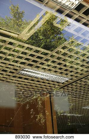 Stock Image - View through a window into an office and reflection of outside. Fotosearch