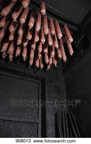 Stock Image - Wacholder salami, a regional specialty from Carinthia, Austria hanging in a smokehouse. Fotosearch