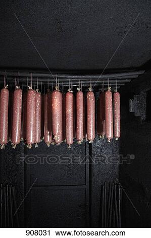 Stock Image - Wacholder salami, a regional specialty from Carinthia, Austria hanging in a smokehouse. Fotosearch