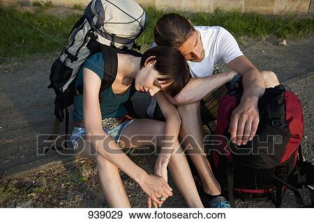 Stock Photo - A backpacker couple waiting on the side of a road. Fotosearch