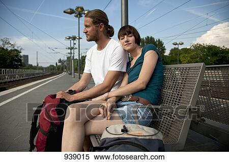 A bored backpacker couple waiting for their train on a train platform View Large Photo Image Stock Photography - A bored backpacker couple waiting for their train on a train platform. Fotosearch