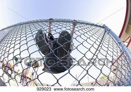 A boy climbing a chain link fence View Large Photo Image Stock Image - A boy climbing a chain link fence. Fotosearch