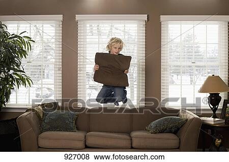 A boy holding a pillow and jumping in mid-air View Large Photo Image Stock Photo - A boy holding a pillow and jumping in mid-air. Fotosearch