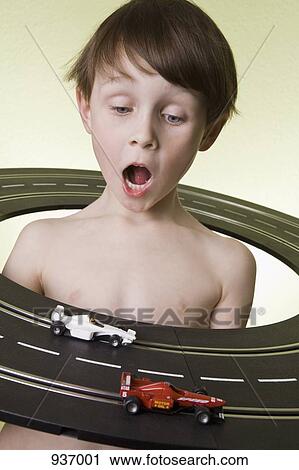 A boy in the middle of a toy racetrack watching the toy racecars race View Large Photo Image Stock Image - A boy in the middle of a toy racetrack watching the toy racecars race. Fotosearch