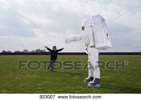 A boy running to meet his astronaut father with his arms outstretched View Large Photo Image Stock Photo - A boy running to meet his astronaut father with his arms outstretched. Fotosearch