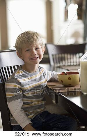 A boy sitting at the dining table having breakfast View Large Photo Image Stock Photography - A boy sitting at the dining table having breakfast. Fotosearch