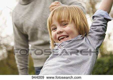 Stock Photo - A boy swinging and laughing. Fotosearch