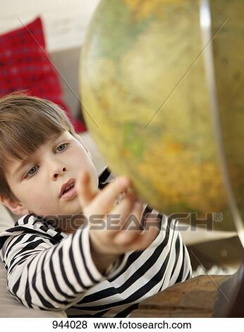 Stock Photo - A boy using a world globe. Fotosearch