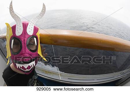 Stock Photography - A boy wearing a mask on a boat. Fotosearch