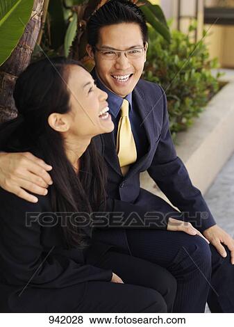 Stock Photo - A business couple sharing a laugh. Fotosearch