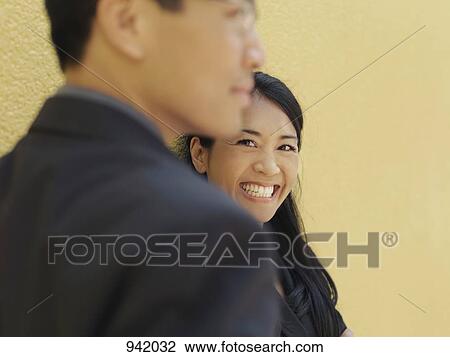A businessman and a smiling businesswoman, focus on woman View Large Photo Image Stock Image - A businessman and a smiling businesswoman, focus on woman. Fotosearch