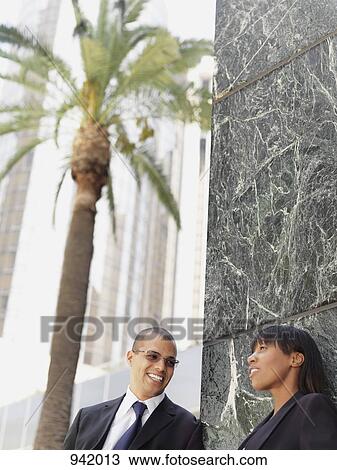 A businessman and businesswoman talking outside an office View Large Photo Image Stock Image - A businessman and businesswoman talking outside an office. Fotosearch