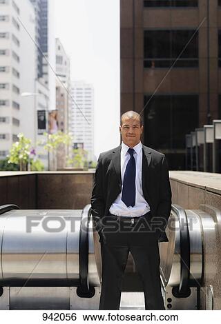 A businessman at the top of an escalator View Large Photo Image Stock Photograph - A businessman at the top of an escalator. Fotosearch