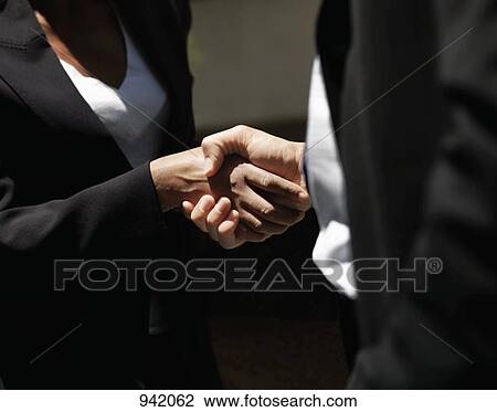 A businessman shaking hands with a businesswoman, midsection, focus on hands View Large Photo Image Stock Image - A businessman shaking hands with a businesswoman, midsection, focus on hands. Fotosearch