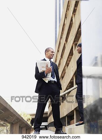 A businessman talking with a businesswoman, outdoors View Large Photo Image Stock Photo - A businessman talking with a businesswoman, outdoors. Fotosearch