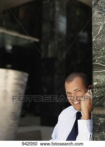 Stock Image - A businessman using a mobile phone. Fotosearch
