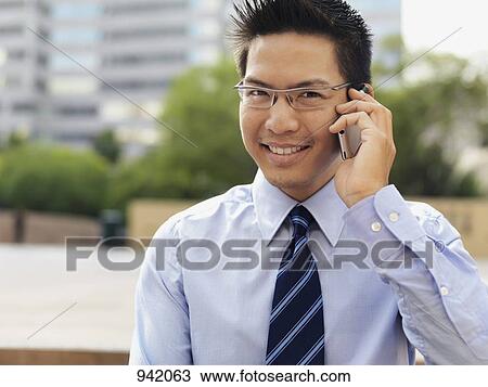 A businessman using a mobile phone View Large Photo Image Stock Image - A businessman using a mobile phone. Fotosearch