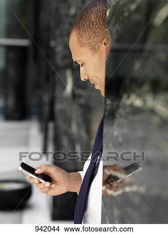 A businessman using a smart phone View Large Photo Image Picture - A businessman using a smart phone. Fotosearch