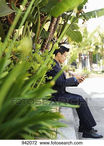 A businessman using a smart phone View Large Photo Image Stock Image - A businessman using a smart phone. Fotosearch