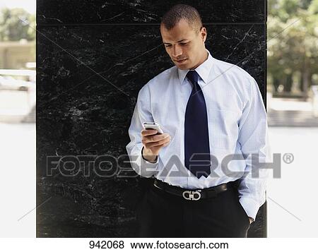 A businessman using a smart phone View Large Photo Image Stock Photo - A businessman using a smart phone. Fotosearch