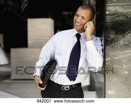 A businessman using on a mobile View Large Photo Image Stock Photo - A businessman using on a mobile. Fotosearch