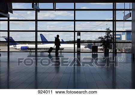 A businessman walking by a window of an airport, silhouette View Large Photo Image Stock Image - A businessman walking by a window of an airport, silhouette. Fotosearch